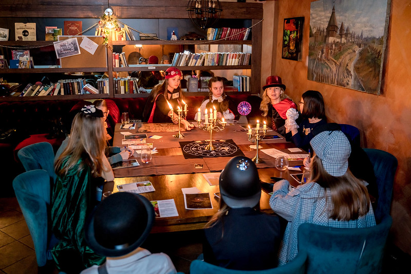 Дети разгадывают загадки в семейном квесте Хэллоуина в Almaty